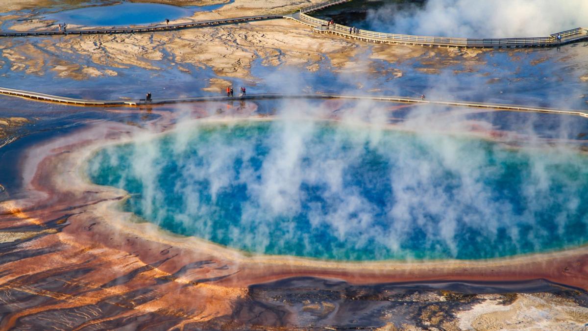 Grand Prismatic Spring from above, steam drifting over its blue center and orange rings