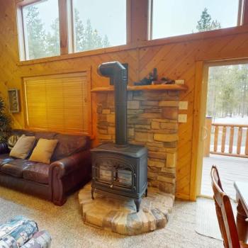 In the center of the room, a stone fireplace rises dramatically, perfect for curling up on chilly evenings.