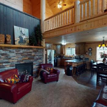 Open living room with seating and a fireplace.