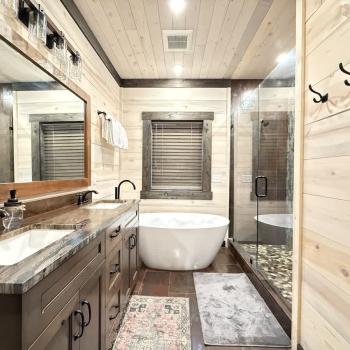 Beautiful shared master bathroom with a large tiled walk in shower and soaker tub.