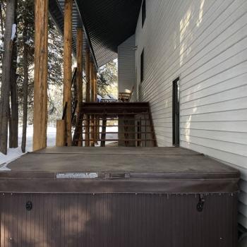 Hot tub is located on the backside of the cabin just down the steps from the wrap around porch.