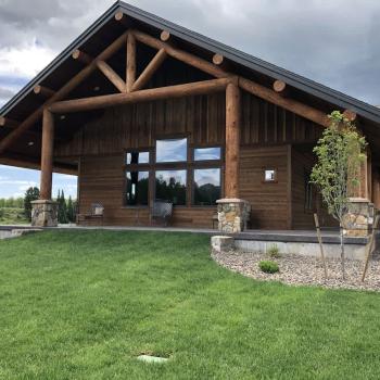 Lots of open grass surrounding the cabin.