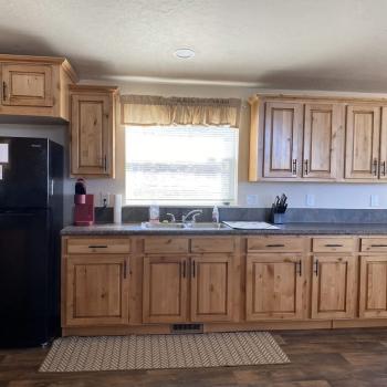 Kitchen with appliances, basic cooking essentials, dishes, silverware, and basic spices.