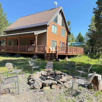 Welcome to Mangy Moose! This beautiful mountain cabin boasts an impressive front porch, a spacious yard with a fire pit, and a peaceful forest setting.