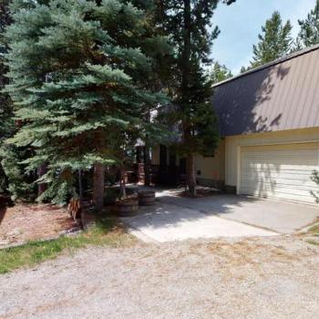 This cabin is nestled in the towering pine trees.