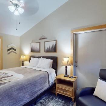 Second bedroom with a queen size bed, seating, and closet.
