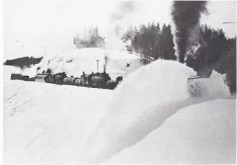 A steam train working through deep snow on the Island Park line