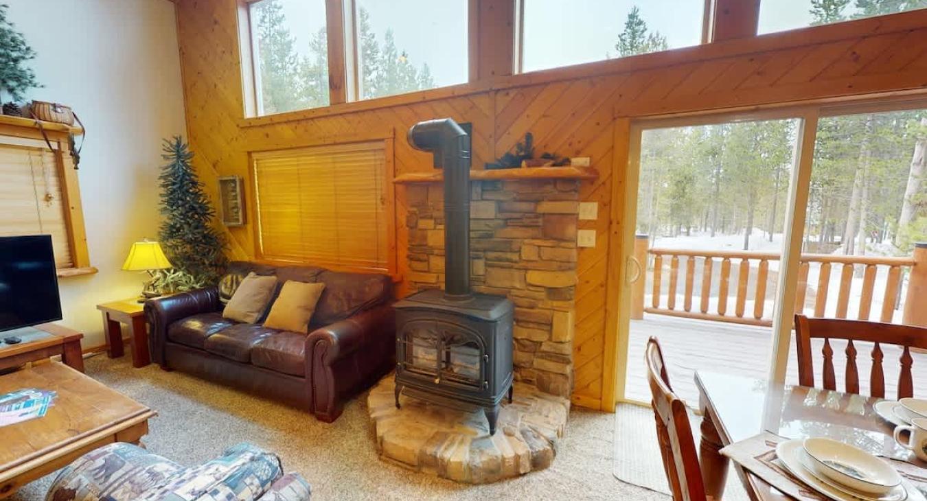 In the center of the room, a stone fireplace rises dramatically, perfect for curling up on chilly evenings.