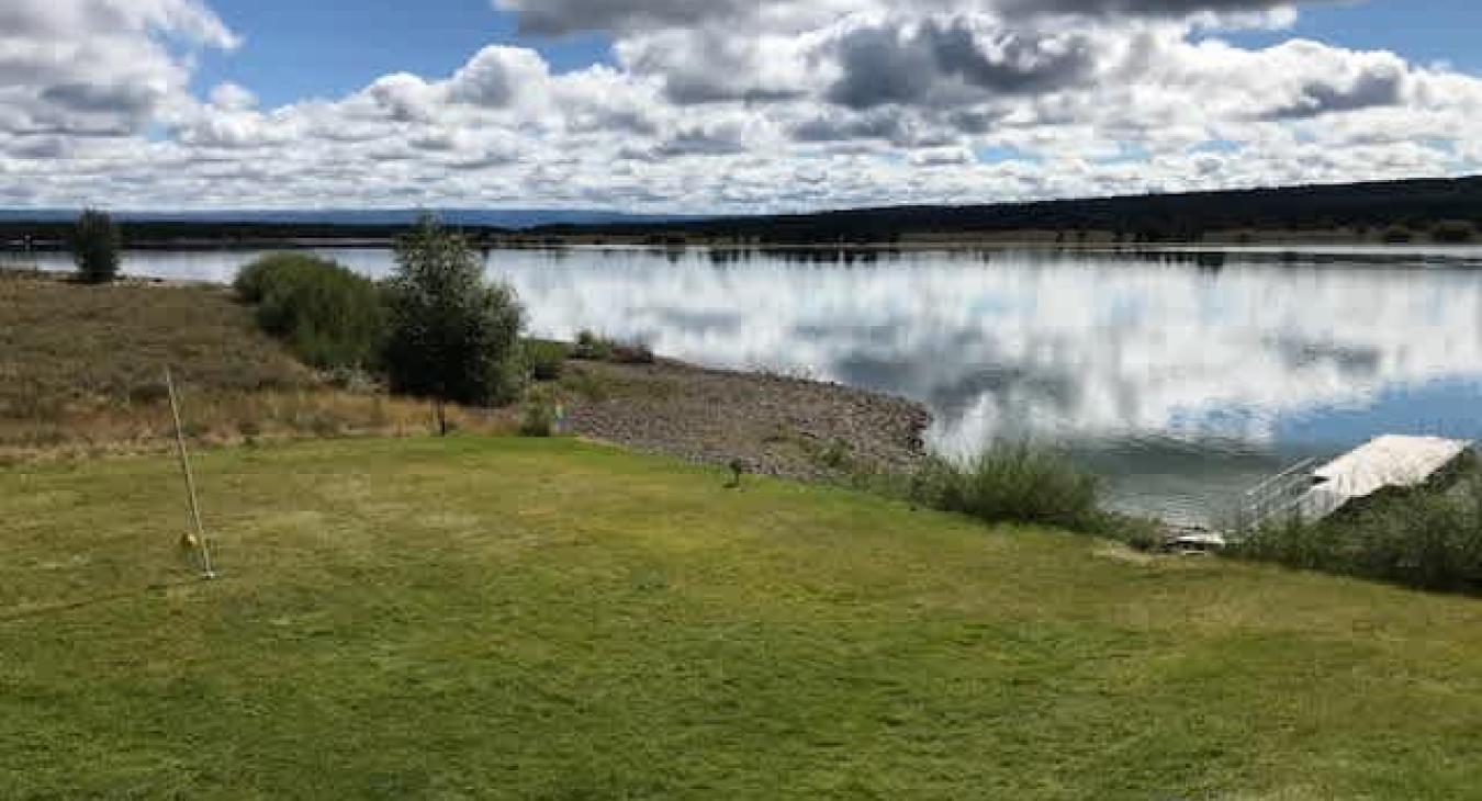 Imagine opening the cabin door to a lush woodland vista falling away into calm water, a private dock inviting you to paddle, and wildlife serenading your peaceful escape