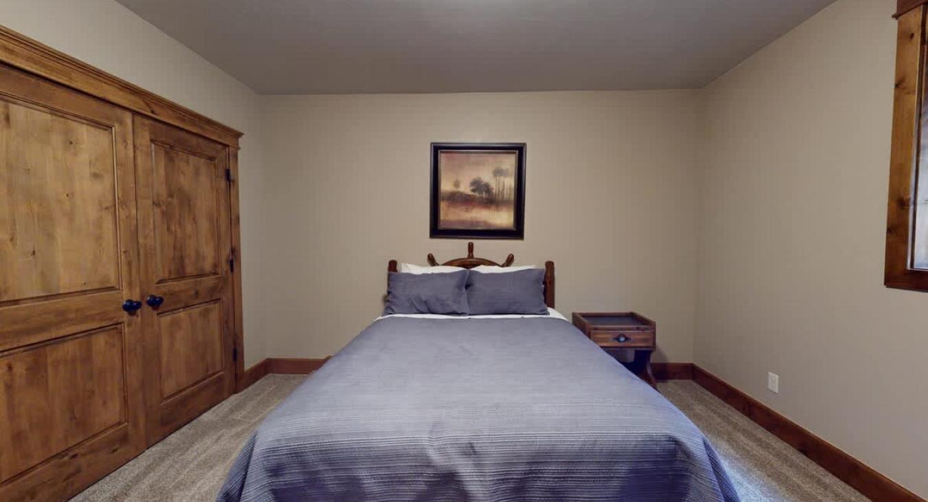 Bedroom #6 located in the basement with a Queen size bed.