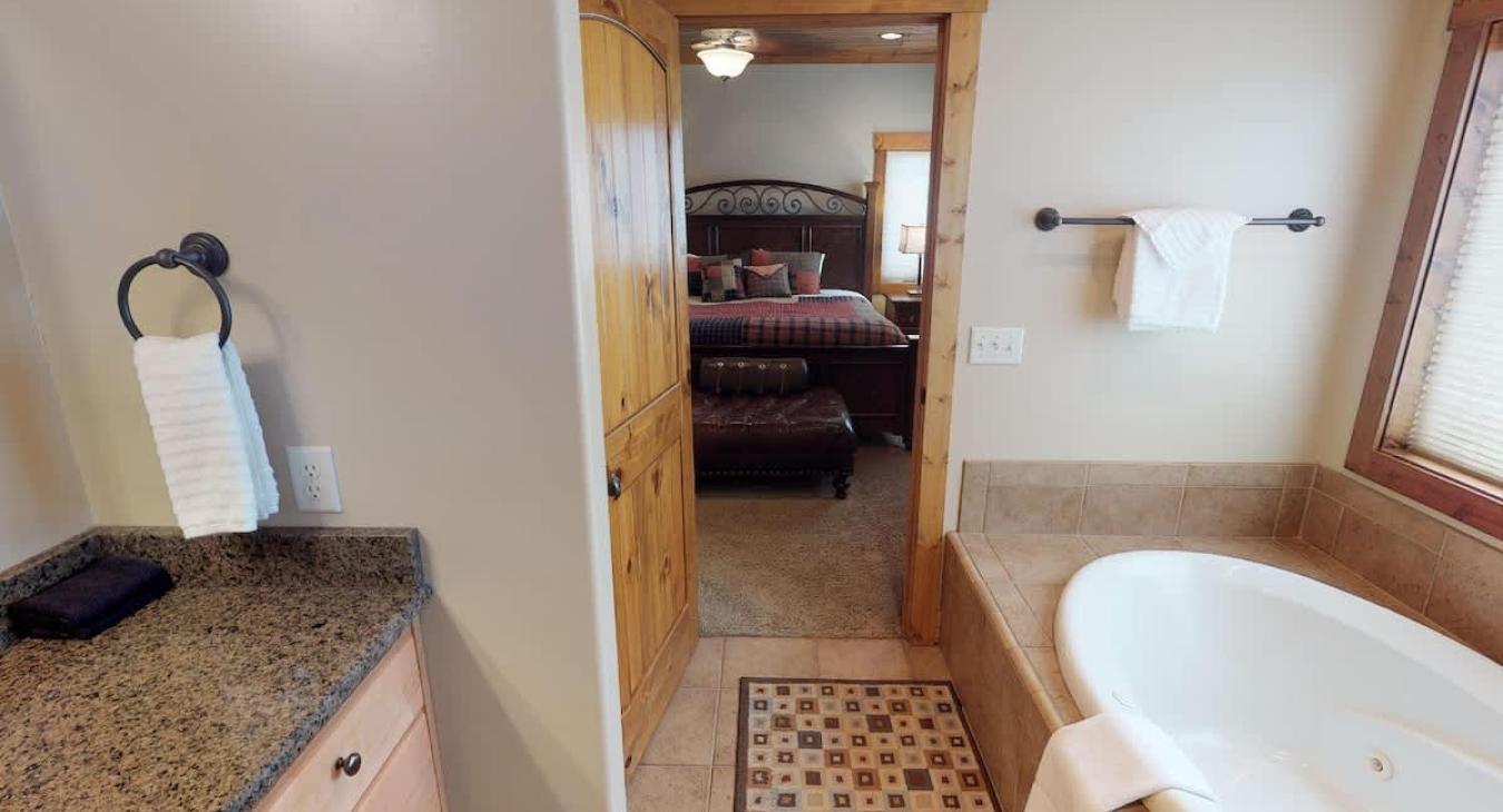From the ensuite bathroom you can view the master bedroom with a king bed.