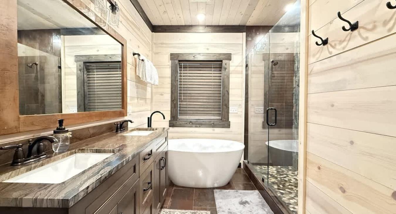 Beautiful shared master bathroom with a large tiled walk in shower and soaker tub.