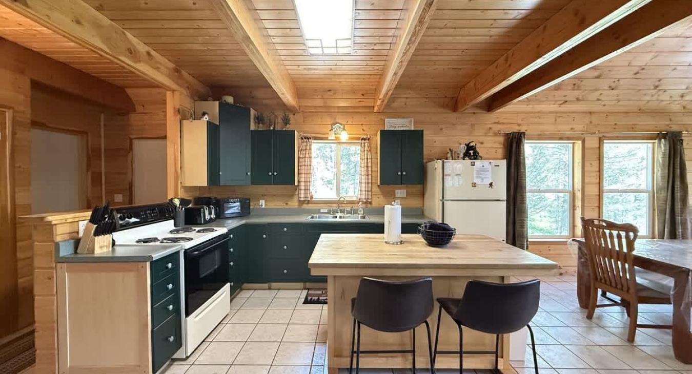 Full kitchen with island to prepare food. Appliances, basic spices, dishes, and silverware are provided.