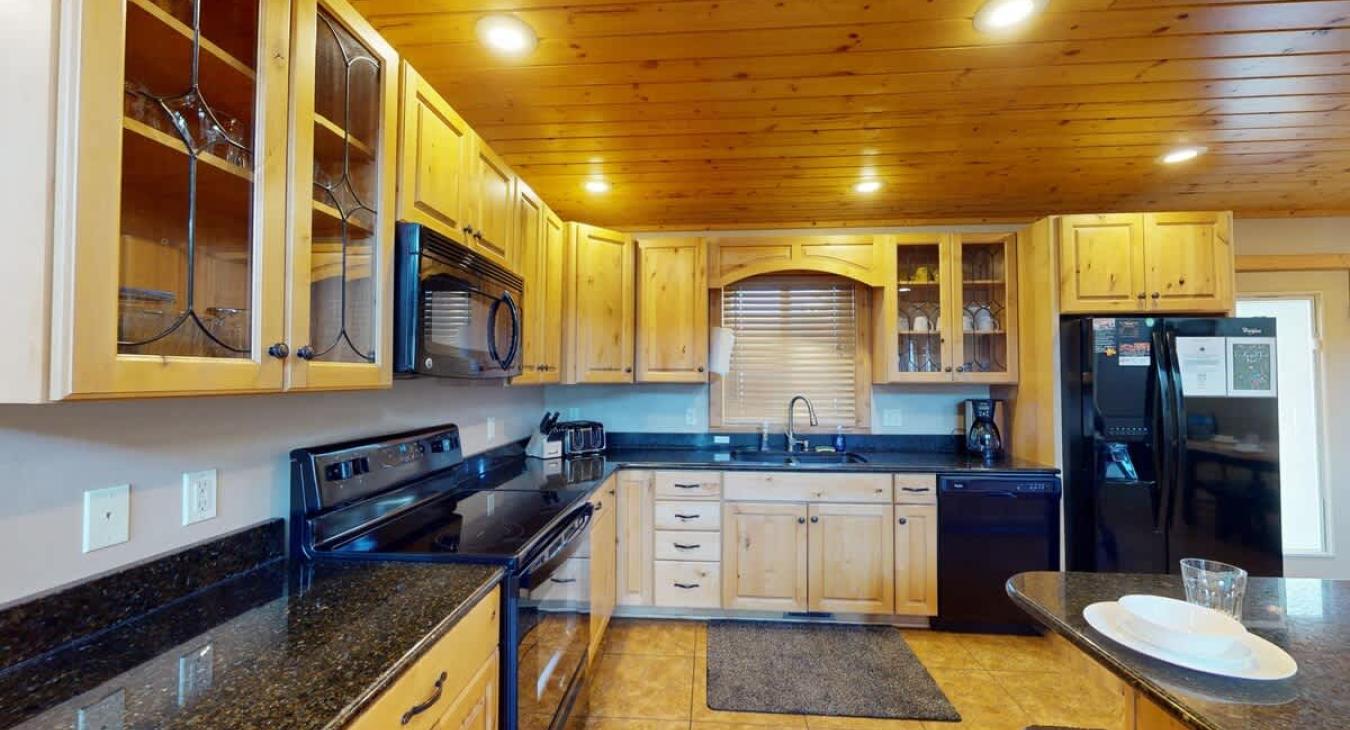 Kitchen is equipped with appliances, cookware, dishes, silverware, and spices.