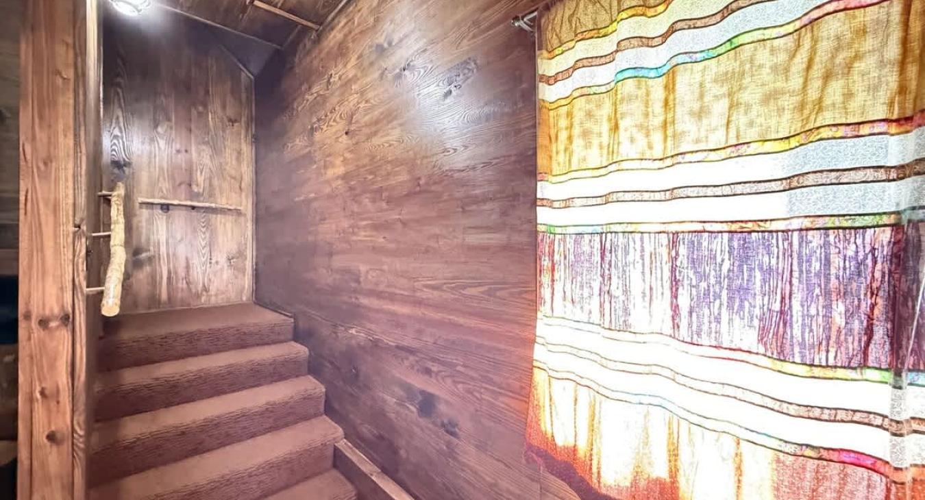 Upon entry of the cabin there are stairs that lead to the bedroom, bathroom, and kitchen.
