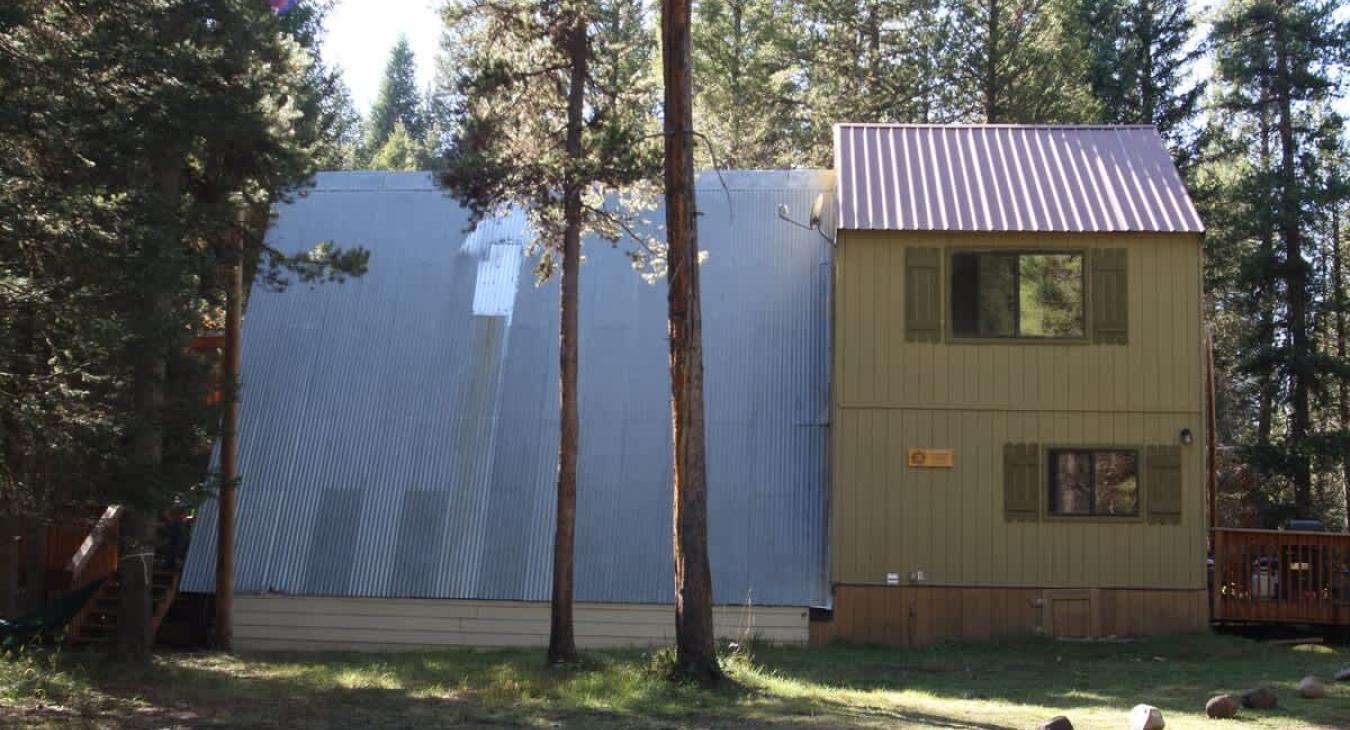 Towering pine and aspen trees surround the cabin,