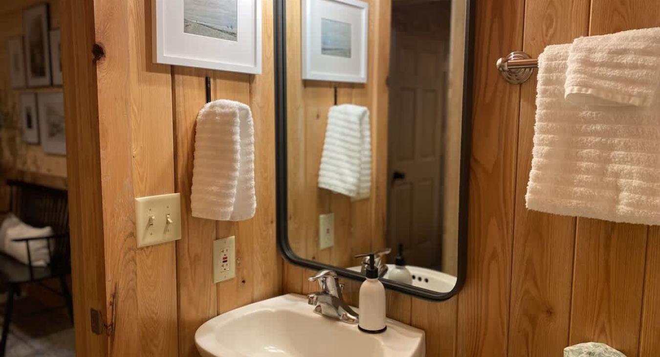Equipped with a shower tub combo, toilet, and sink.