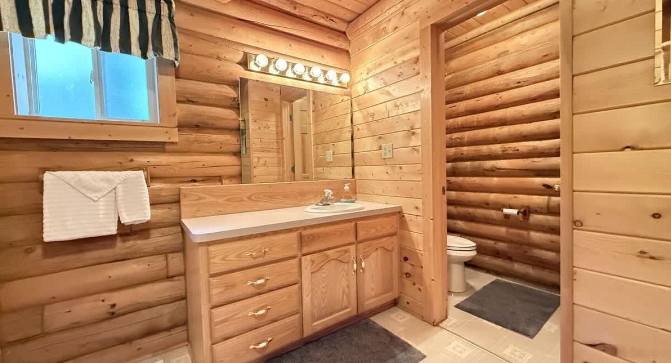 Main level bathroom with shower/tub, toilet, and sink.