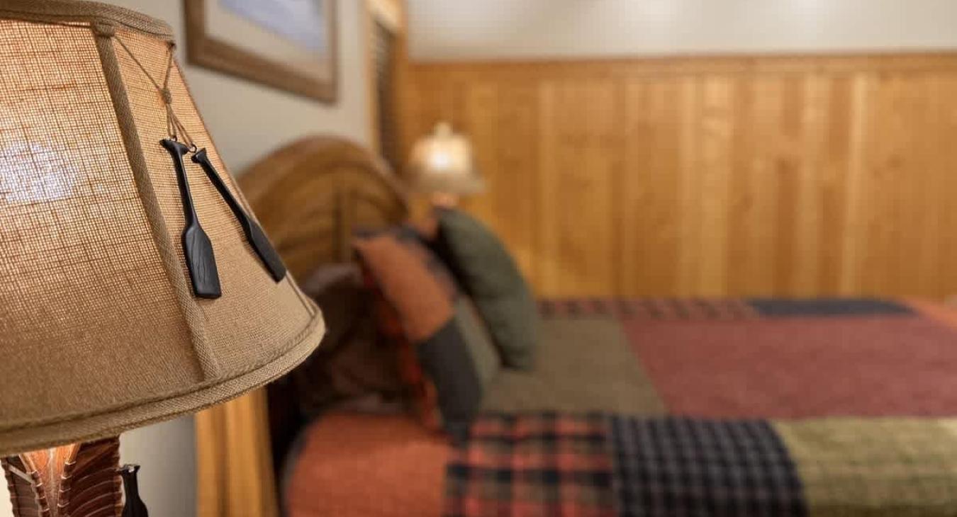 A cozy cabin bedroom that feels like a hug from nature—with a queen-size bed as the centerpiece.