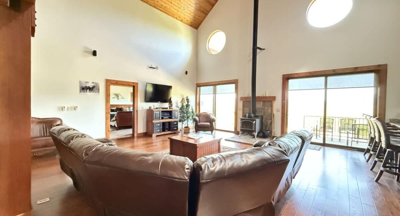 Living room on the main floor with large couch, television, and fireplace.
