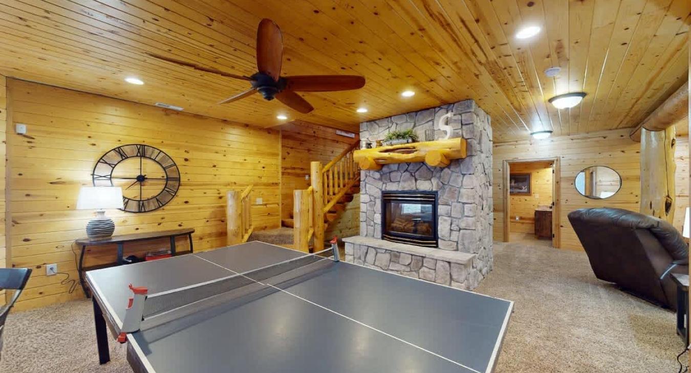 As you enter, there is a table tennis table, situated in the center of the room, ready for a friendly match or a lively competition. The space around it is open, allowing for plenty of room to move, serve, and dive for the ball.