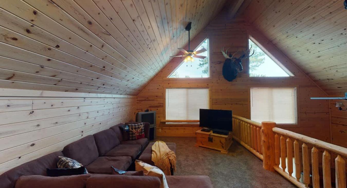 Upstairs loft living area with seating, Hide abed, and tv for entertainment.