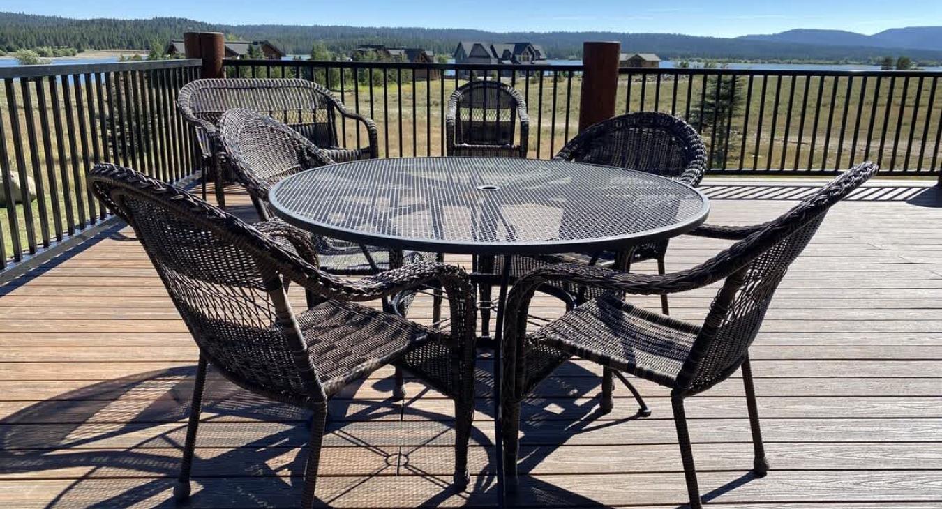 In the center of the deck, one large round table with seating are positioned for outdoor dining.
