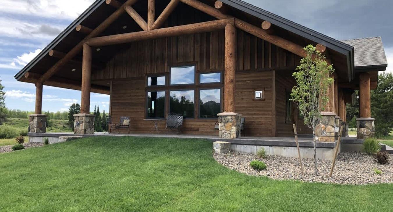 Lots of open grass surrounding the cabin.