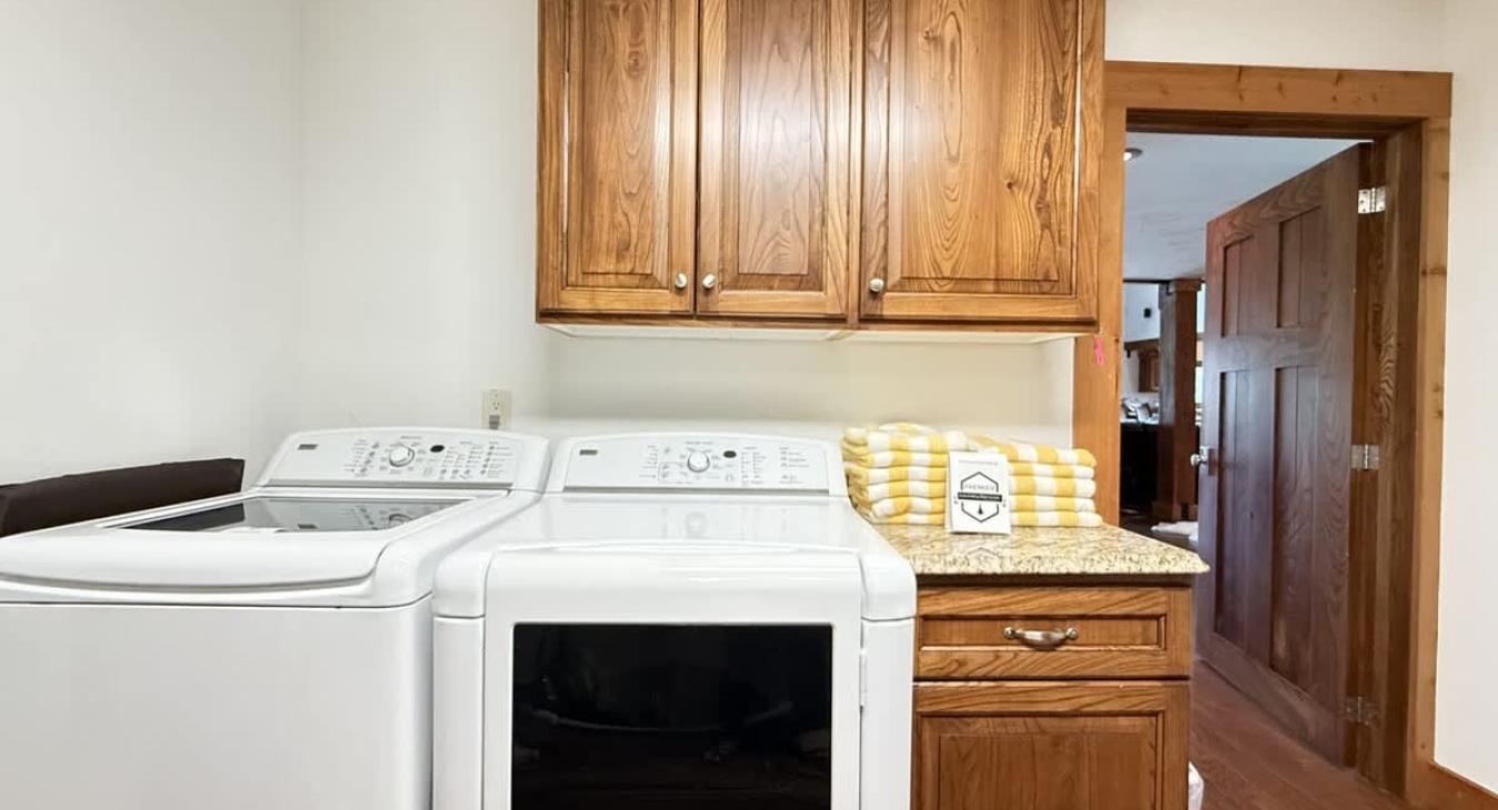 Laundry room with full size washer and dryer with laundry soap provided.