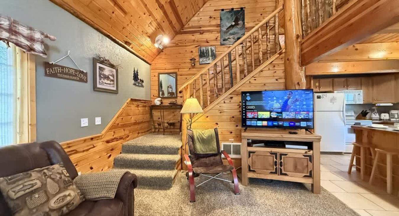 Main level open living room with smart tv that leads to the upstairs.