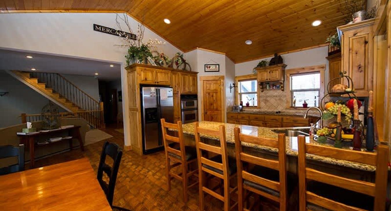 Dining area with a full dining room table and additional seating at the kitchen.