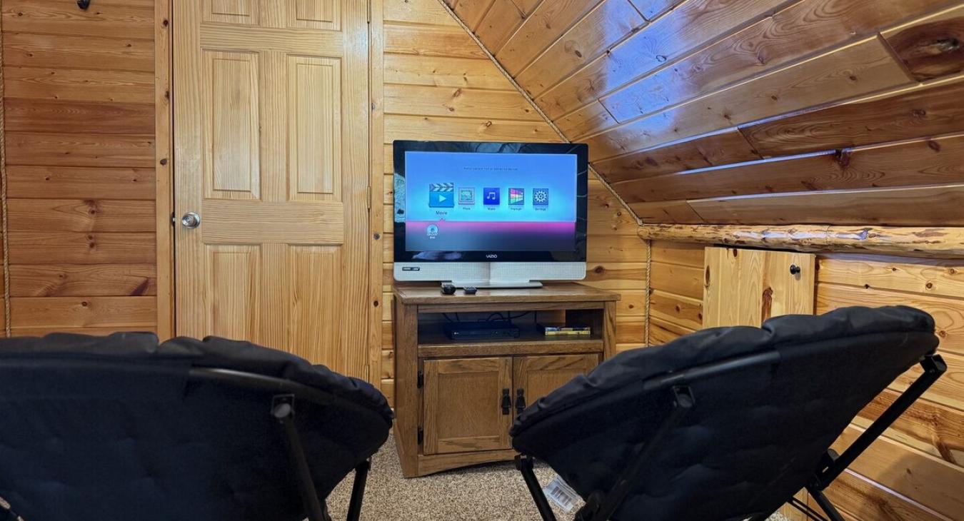Tv and small chairs upstairs in the loft.