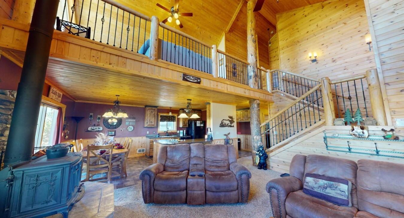 Upon entry is a large living room with seats and views of the loft upstairs.