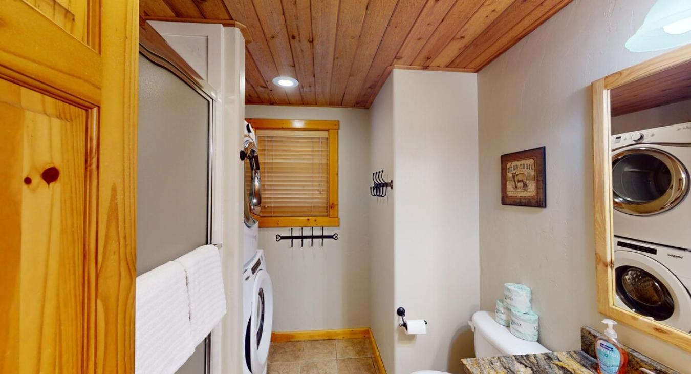 Downstairs full size bathroom with a stacked washer and dryer. Laundry soap is also provided.