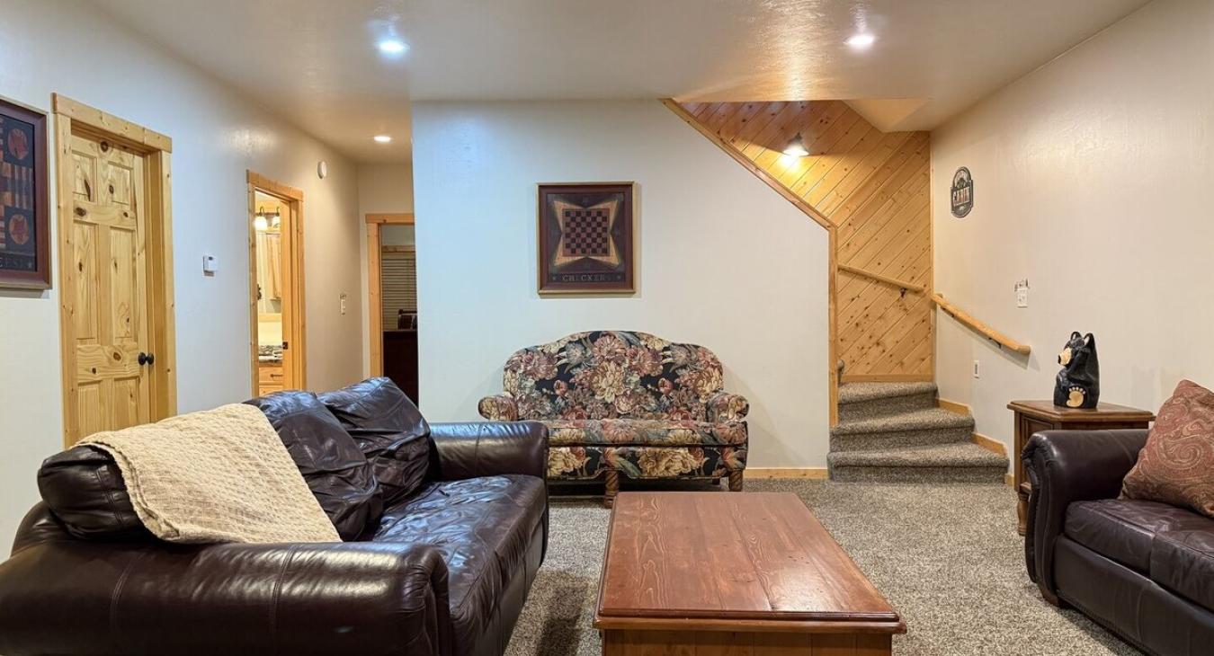 As you walk down the stairs, you're greeted by warm, ambient lighting and the gentle crackle of a fireplace.