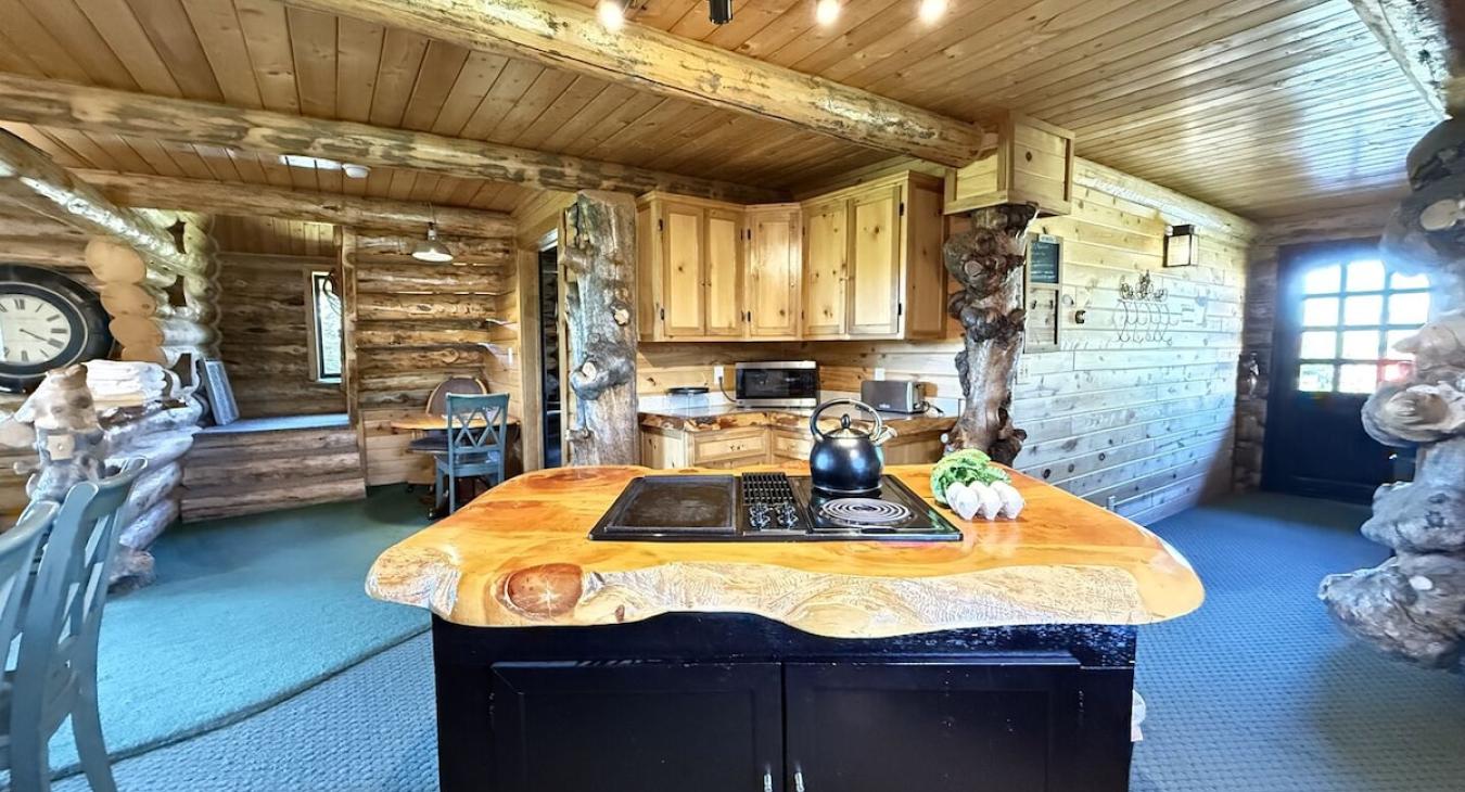 The kitchen in the cabin is a space that feels both functional and comforting, a place where family and friends can gather, cook, and enjoy each other’s company in the heart of the home.