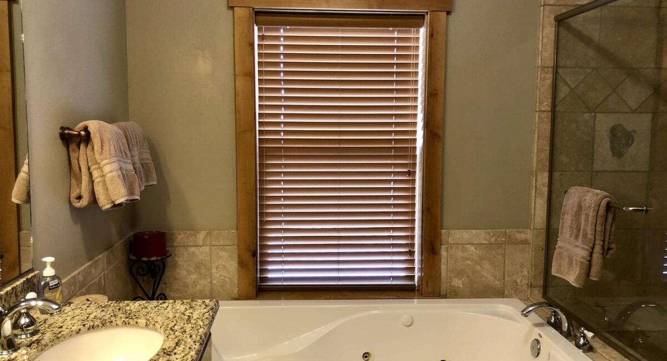 Bathroom is equipped with a soaking tub, standing shower, toilet, and double sink vanity.