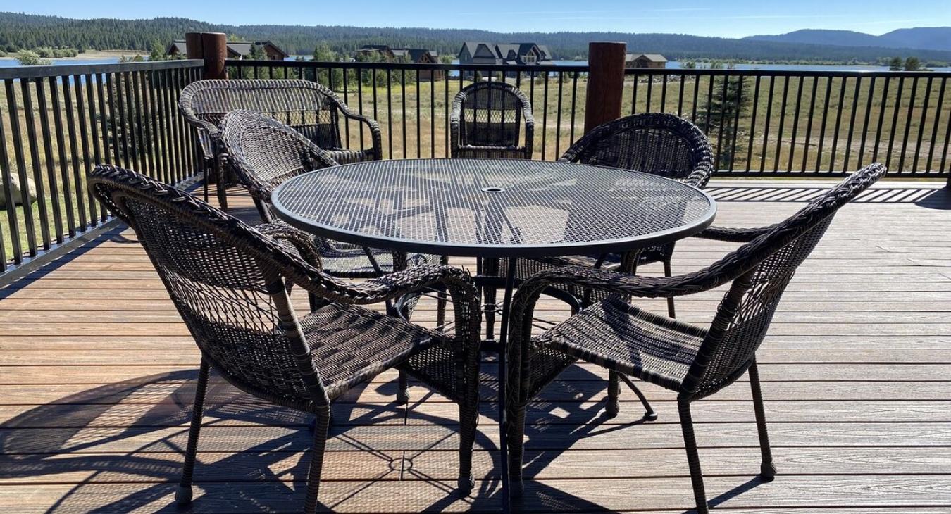 In the center of the deck, one large round table with seating are positioned for outdoor dining.
