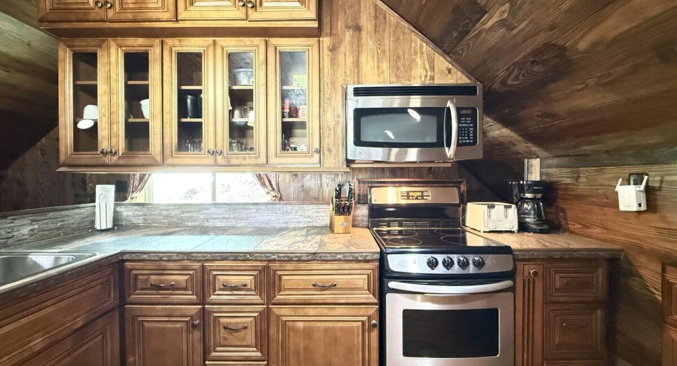 Upstairs is the kitchen with a stove, oven, microwave, fridge. and sink.