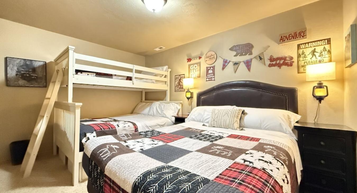 Downstairs bedroom #2, perfect for up to 5 people. This room features a queen bed and a bunk bed with a twin and double bed.