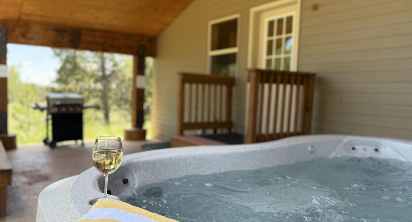 Hot tub and grill are conveniently located outside in the back of the cabin.