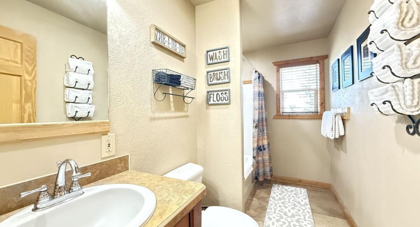 Upstairs bathroom with shower tub combo, toilet, and sink vanity.