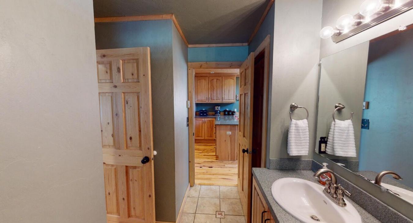 Shared downstairs bathroom with shower tub combo, toilet, and sink vanity.