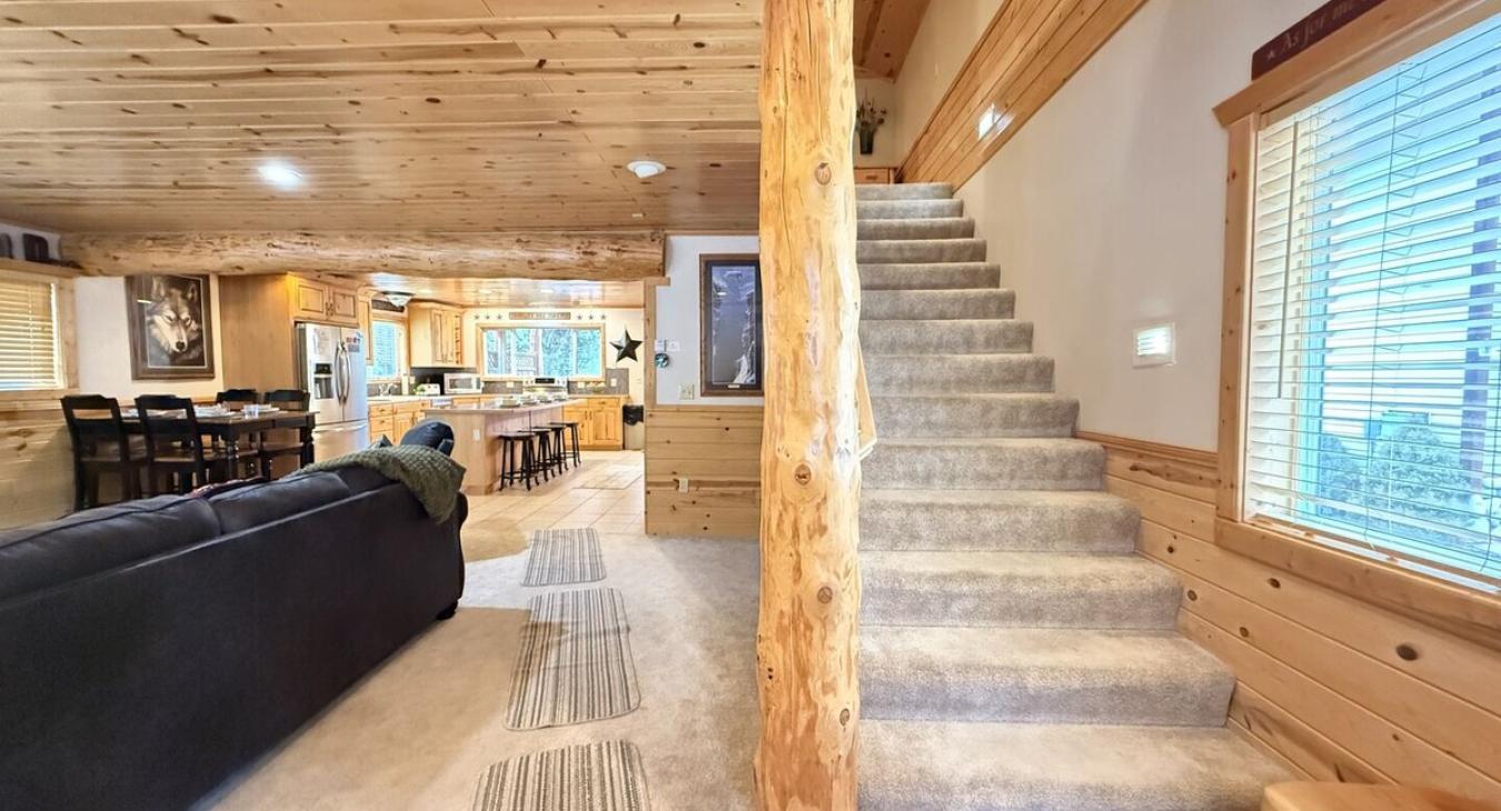 View of the stairs and the open living room and kitchen.