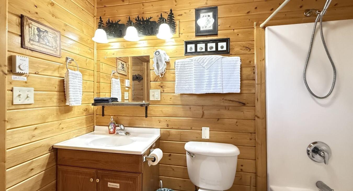 The main bathroom is equipped with a shower tub combo, toilet, and sink vanity.