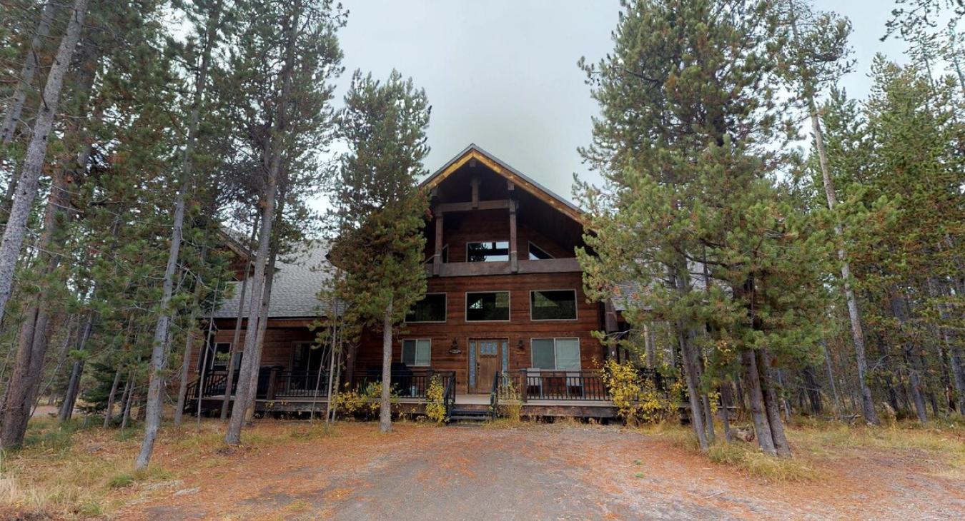 Nestled in the trees is this beautiful handcrafted log cabin.