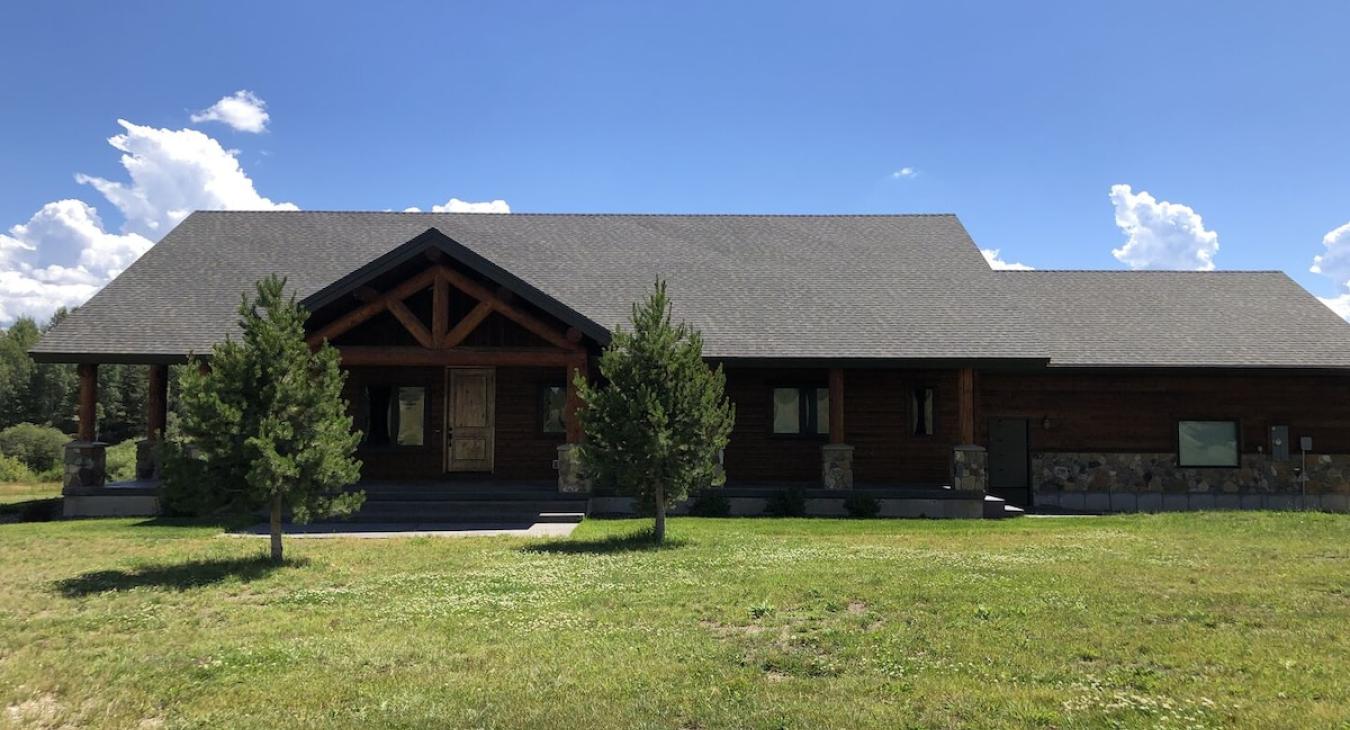 Lots of open grass surrounding the cabin.