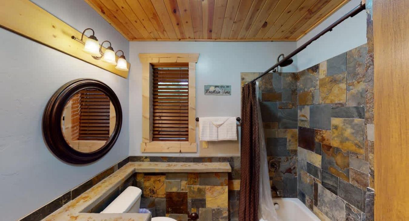 Bathroom located in the basement with shower/tub, toilet, and sink vanity.