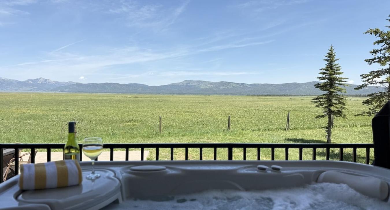 Hot tub with panoramic meadow views.