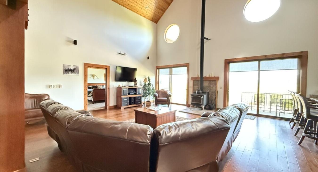 Living room on the main floor with large couch, television, and fireplace.